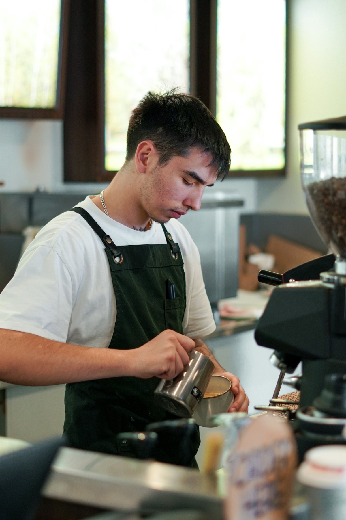 Barista steaming milk at the espresso machine